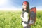 Tourist woman with backpack in the flower field