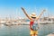 Tourist woman with backpack in sea port with rows of yachts