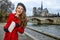 Tourist woman on embankment near Notre Dame de Paris with map