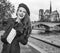 Tourist woman on embankment near Notre Dame de Paris with map