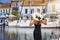 A tourist woman with hat enjoys the view to the marina of Fiskardo, Cephalonia, Greece