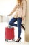 Tourist woman legs waiting with a suitcase in an airport