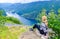 Tourist woman looks at cruise liners at the end of Geirangerfjord, near small village of Geiranger. View from Eagles Road. Norway