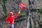 Tourist woman with norwegian flag in rocks mountains