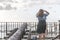 A tourist woman observes the sea while it is next to a grand canyon