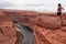 Tourist woman with panoramic aerial view of Horseshoe bend on the Colorado river near Page in summer, Arizona, USA