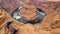 Tourist woman with panoramic aerial view of Horseshoe bend on the Colorado river near Page in summer, Arizona, USA