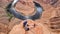 Tourist woman with panoramic aerial view of Horseshoe bend on the Colorado river near Page in summer, Arizona, USA