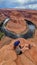 Tourist woman with panoramic aerial view of Horseshoe bend on the Colorado river near Page in summer, Arizona, USA