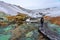 Tourist woman on the path of colorful krysuvik seltun on reykjanes peninsula in Iceland