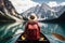 Tourist woman is sailing on a boat on a transparent lake among the mountains. Back view. Ai generated
