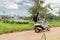 Tourist woman on a scooter with backpack looking a beautiful ocean view.