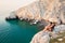Tourist woman sit enjoy panorama on viewpoint in persian gulf Mirellas island. Musandam.Oman