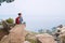 Tourist woman sitting with city backpack and enjoying ancient city harbor on the Ionian seacoast. Small Italian Castelmola Comune