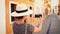 Tourist woman with straw sunhat taking a picture of a narrow street of Denia in Alicante, Spain.