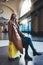 Tourist woman with suitcase on platform station in Barcelona. Smile girl traveler waiting train enjoy holiday weekend vacation