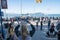 Tourist woman takes photos of Alcatraz from Pier 39 at a busy area of the pier, with