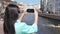 Tourist woman taking photo using smartphone of floating boat river surrounded by historic city