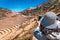 A tourist woman taking a picture of the ruins of Pisac with her smartphone in the Sacred Valley of the Incas