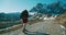 Tourist woman walk on beautiful mountain road with backpack on vacation travel