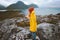 Tourist woman walking in Norway mountains vacations outdoor adventure lifestyle girl wearing yellow raincoat