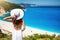 A tourist woman in white dress gazes the famous beach of Myrtos, Kefalonia, Greece