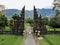 Tourist woman in white dress walking through Traditional Balinese Hindu gate Candi Bentar close to Bedugul, Bratan lake