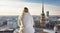 A tourist woman in white winter clothes enjoys the panoramic view over the skyline. Generative AI
