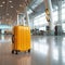 Tourist yellow suitcase at floor airport on background, bright luggage waiting in departure lounge hall of airport