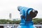 Touristic telescope look at the city with view of Barcelona Spain, close up old blue binoculars on green nature background view