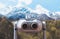 Touristic telescope look at the city with view snow mountains, closeup binocular on background viewpoint observe vision