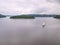 Touristic yacht sailing on dam. Dark cloudy sky before rain