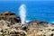 Tourists admiring the Nakalele blowhole on the Maui coastline. A jet of water and air is violently forced out through the hole in