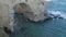 Tourists admiring the sea from natural stone arch on cliff, Torre Sant Andrea.