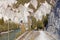 Tourists approaching Versam-Safien train station while observing symbols on stone wall in sunny autumnal Ruinaulta