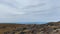 Tourists with backpacks and trekking poles are walking along the tundra. Distant shot.