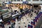 Tourists in baggage claim area in the airport with social distance markings