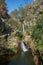 Tourists in beautiful waterfall in Penedo Furado Passadico walkway in Vila de Rei, Portugal