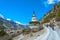 Tourists and big stone stupa on mountain road, Nepal.