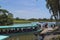 Tourists boarding boat moored beside pier on river with green landscape under sky