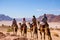 tourists on camels observing wildlife in a desert reserve