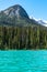 Tourists canoe on the teal water of Emerald Lake in Yoho National Park Canada
