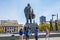 Tourists from China taking pictures at the background of the sculpture of Lenin and the Novosibirsk state academic Opera and ball