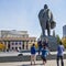 Tourists from China taking pictures at the background of the sculpture of Lenin and the Novosibirsk state academic Opera and ball