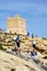 Tourists on the cliffs by Blue Grotto tower, Malta.