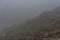 Tourists climb Poland`s popular mountain peak - Sniezka in the Giant Mountains in cloudy weather