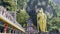 Tourists climb the stairs to Batu Cave in Kuala Lumpur, near the golden statue of god Murugan