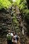 Tourists climbing iron ladders in Slovak Paradise