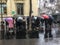 Tourists cluster under umbrellas listening to guide, Paris, France