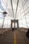 Tourists and commuters walk along the pedestrian deck of the Brooklyn Bridge, lower Manhattan